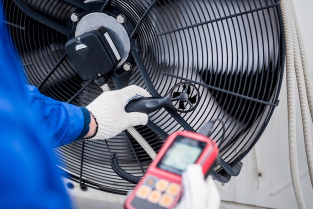 Testando com um anemômetro de um ventilador axial da unidade condensadora