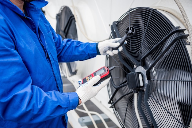 Testando com um anemômetro de um ventilador axial da unidade condensadora