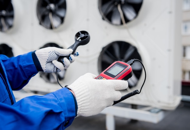 Testando com um anemômetro de um ventilador axial da unidade condensadora