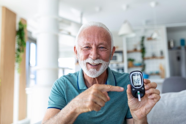 Teste de açúcar no sangue em casa Verificando o nível de açúcar no sangue em casa Diabético Verificando os níveis de açúcar no sangue Homem sênior verificando o nível de açúcar no sangue por glicosímetro e tira de teste em casa