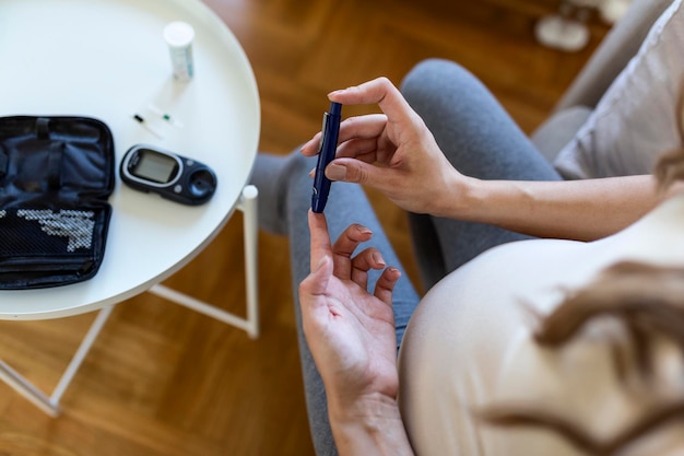 Teste de glicose no sangue para diabetes em mulheres grávidas com glicômetro. Uma gota de sangue vermelha no dedo pronto para medir o nível de açúcar. Close-up de dedo masculino com gota de sangue e faixa de teste