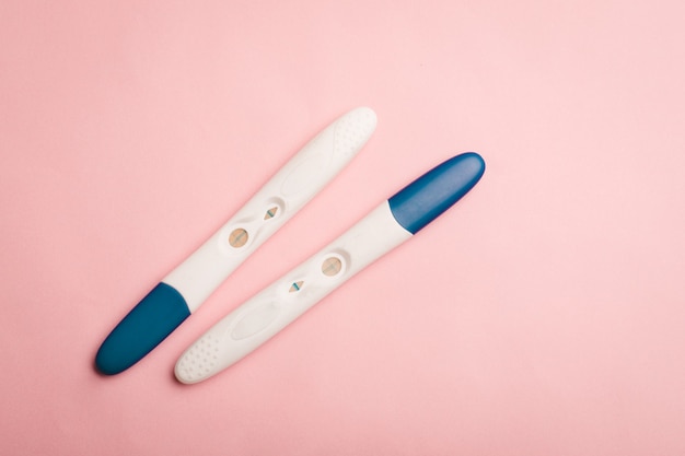 Teste de gravidez em um fundo rosa. teste positivo. espaço da cópia da gravidez.