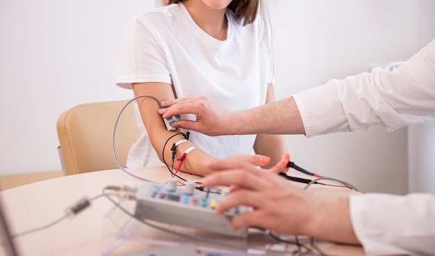 Teste de nervos do paciente usando eletromiografia em centro médico