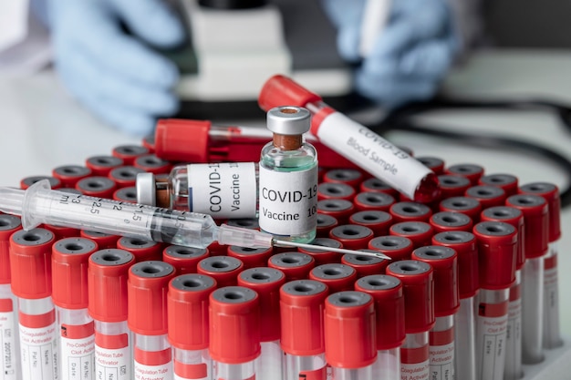 Foto teste de sangue covid-19 em tubos e frascos de vidro de vacina
