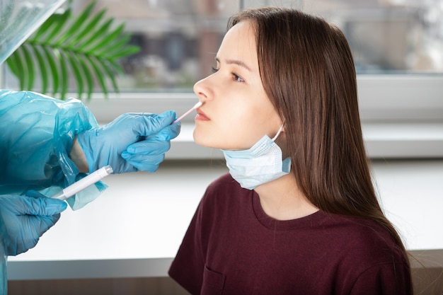 Teste de swab para coronavírus um médico em traje de proteção faz uma análise em um hospital médico de saúde e segurança