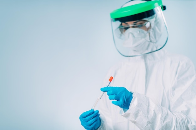 Teste de vírus corona Trabalhador médico em suíte protetora branca com amostra de cotonete para teste de DNA PCR