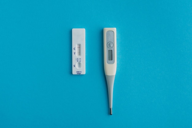 Teste expresso para covid19 com resultado positivo e um termômetro kit de autoteste coronavirus