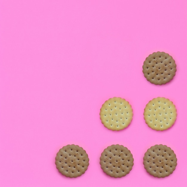 Teste padrão do biscoitos marrons em um fundo cor-de-rosa.