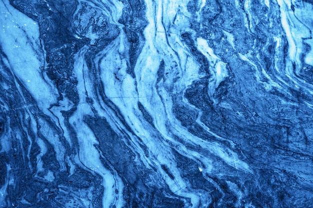Teste padrão encaracolado na pedra de mármore para o azul clássico da cor da tendência do fundo. Textura de mármore natural. Mármore do desfiladeiro Ruskeala. Rússia.