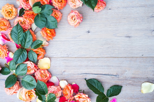 Teste padrão floral, moldura feita de rosas sobre fundo de madeira.