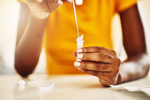 Teste para o vírus da coroa covid ou infecção com um kit de teste rápido de antígeno em casa Close de uma mulher casual se examinando com um kit para diagnosticar uma doença doença ou doença viral infecciosa