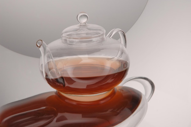 Tetera de cristal transparente y taza con té