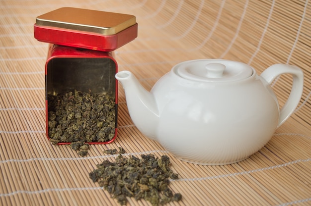 Tetera y una lata de té verde asiático tradicional suelta