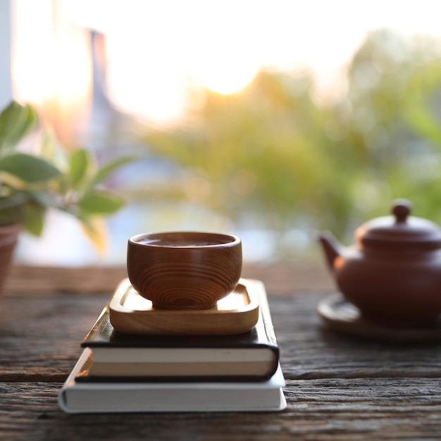 Tetera marrón y taza de té y libros.