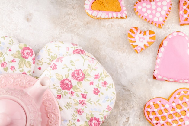 Tetera rosa, guantes de flores y plato de galletas glaseadas a mano en forma de corazón