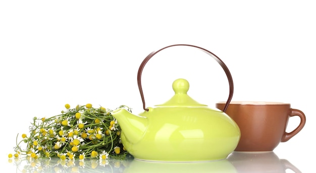 Tetera y taza con té de manzanilla aislado en blanco