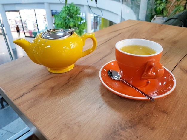 Tetera y taza de té en una mesa de madera Taza de té de espino amarillo