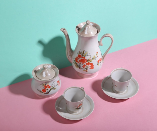 Tetera y tazas retro sobre fondo azul rosa Minimalismo Sombra de moda Diseño creativo