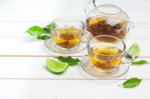 Tetera y tazas de té sobre un fondo blanco de madera