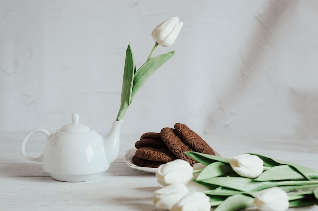 Tetera con té y flor primavera bodegón