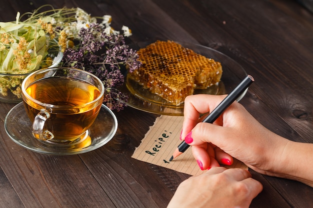 Tetera con té de hierbas en la mesa de la cocina