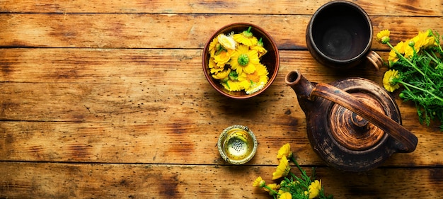 Tetera de vidrio con té de flores, espacio para texto