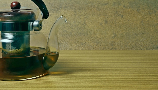 Foto tetermão de vidro transparente meio cheio de chá