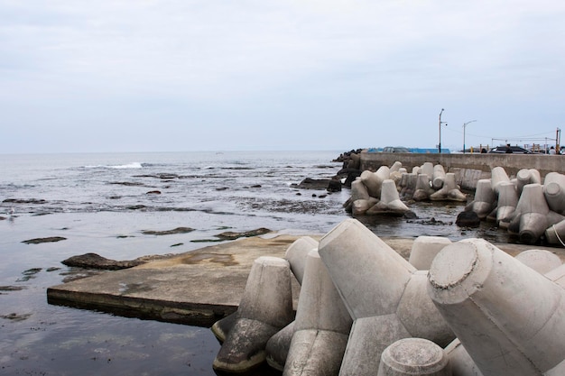 Foto el tetrápodo de bloques de hormigón para el rompeolas y la disipación del agua de las olas previene la erosión en el embarcadero de pesca en el mar y el océano del este de japón en la ciudad de pohang de gyeongsangbuk o corea del sur de gyeongsang del norte