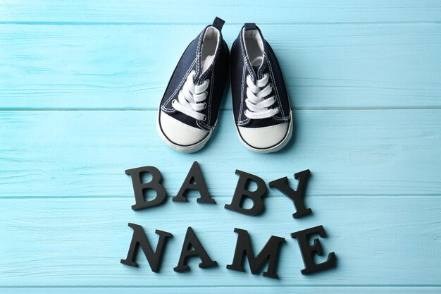 Foto text babyname und schuhe auf farbigem holzhintergrund