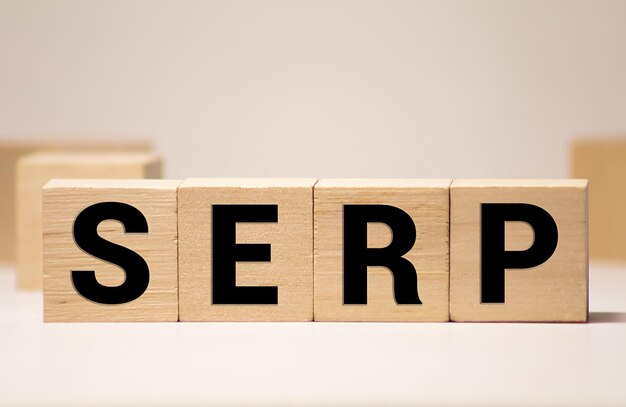 Text des Wortes SERP auf hölzernen Würfeln auf einer schwarzen Tastatur