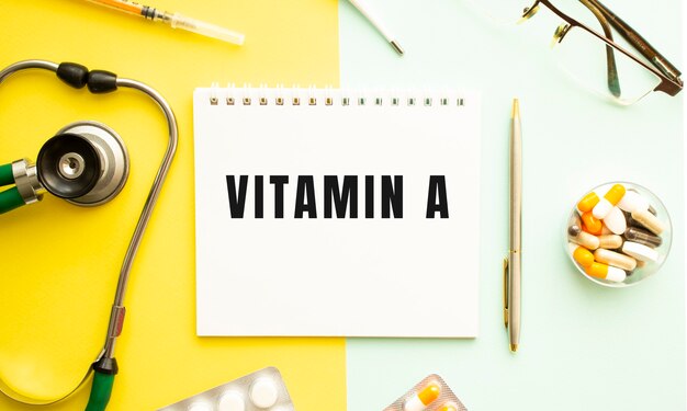 Foto text vitamin a auf notizbuch mit stethoskop und stift