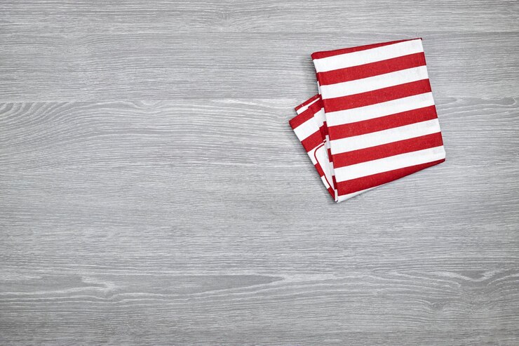 Foto textil de cocina de lino a rayas blancas y rojas sobre mesa de madera gris