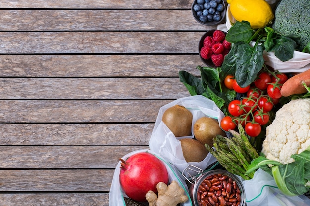 Textile Netztasche mit Produkten, Obst und Gemüse. Zero Waste, umweltfreundlich, plastikfrei recycelt, wiederverwendbar, nachhaltiges Lebensmitteleinkaufskonzept. Platz kopieren, flacher Hintergrund