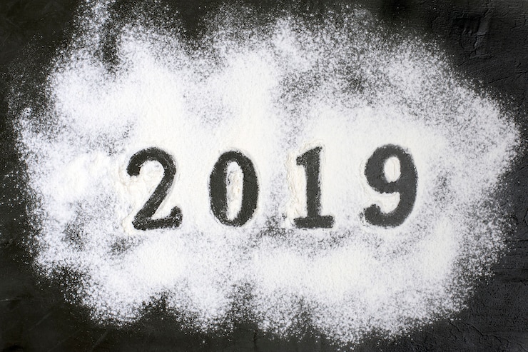 Foto texto 2019 hecho con harina con decoraciones sobre fondo negro. feliz navidad feliz n