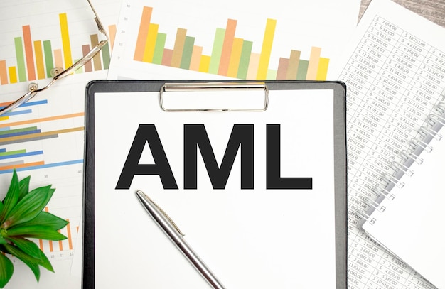 Texto AML AntiMoney Laundering en el bloc de notas en la mesa de madera