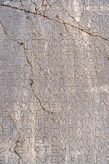 Texto antiguo griego antiguo e inscripciones en la pared de piedra del templo Alfabeto de la cultura griega antigua y concepto de historia de fondo de escritura