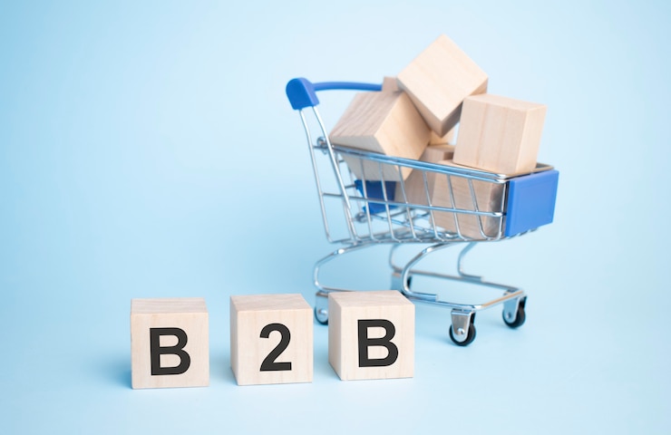 Foto texto b2b en cubo de madera con carrito de compras aislado sobre fondo.