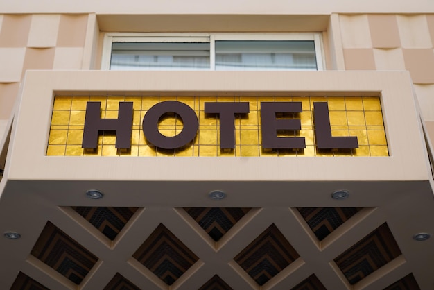 Texto del cartel del hotel en la fachada de entrada del edificio de la pared en la ciudad turística