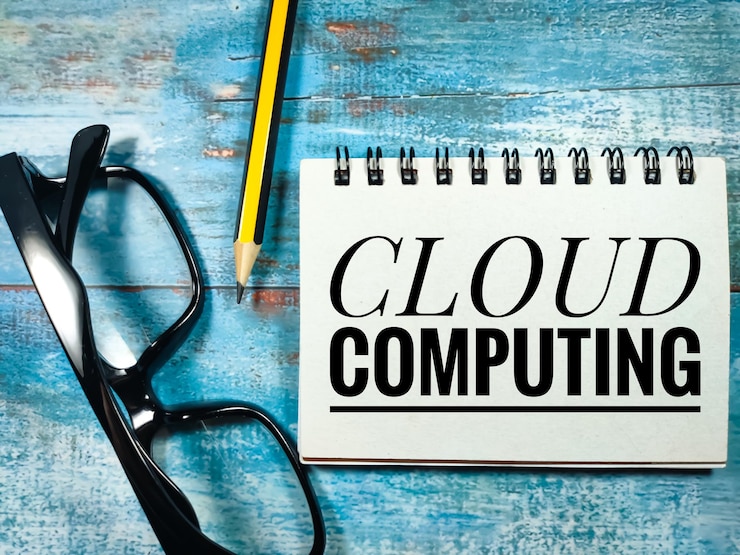 Foto texto cloud computing escrito en un cuaderno con lápiz y gafas sobre fondo de madera azul
