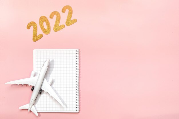 Texto de 2022 em fundo rosa Projeto plano de mesa de trabalho com planejamento ou caderno