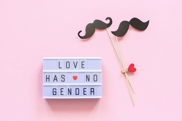 Texto de caixa de luz "O amor não tem gênero" e adereços de bigode de papel casal