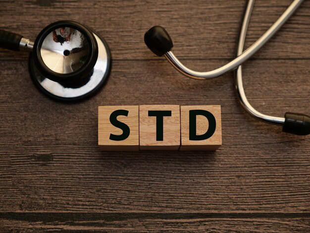 Foto texto de doença sexualmente transmissível escrito com letras de madeira conceito de saúde e médico