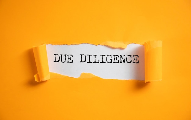 Texto de due diligence no papel rasgado