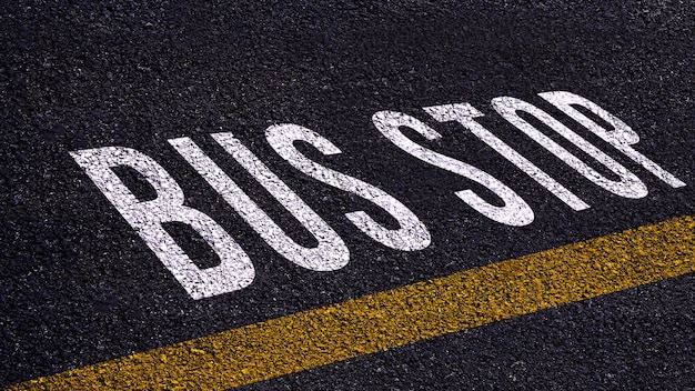 Texto de parada de ônibus escrito e linha amarela na estrada no meio da estrada de asfalto Palavra de parada de ônibus na rua