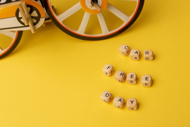 Texto Día sin coches y pequeña bicicleta de juguete sobre fondo amarillo Concepto del día mundial sin coches