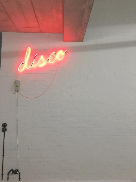 Foto texto de discoteca iluminado en la pared