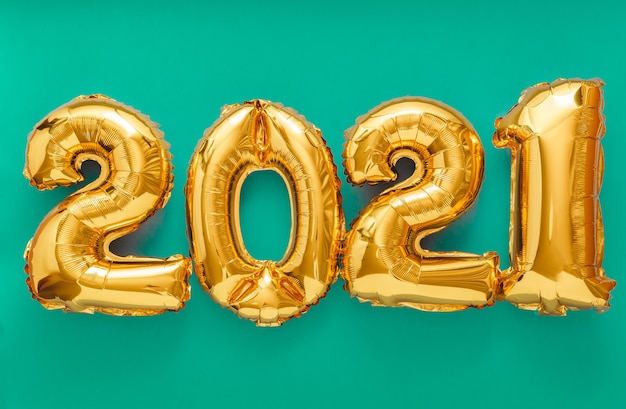 Texto do balão de 2021 em verde. convite de feliz ano novo com balões de folha de ouro de natal 2021.