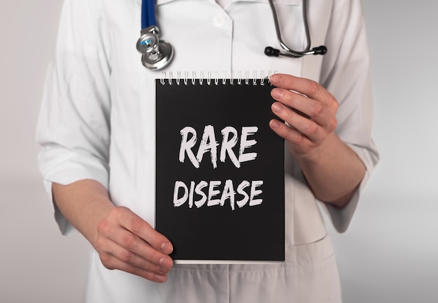 Texto de enfermedades raras en papel en manos del médico
