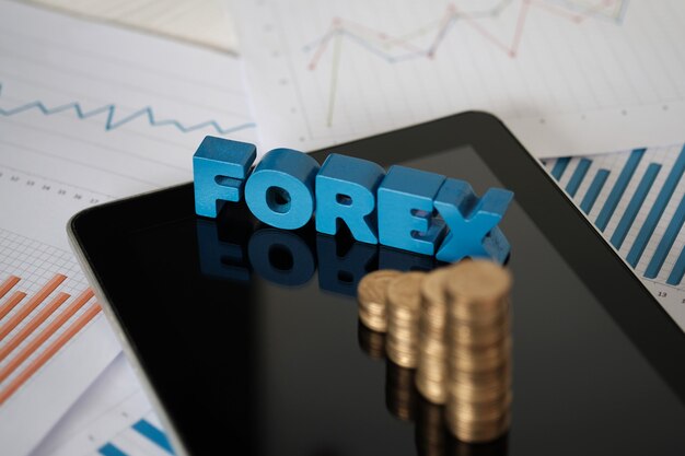 Texto forex e pilha de moedas com tablet