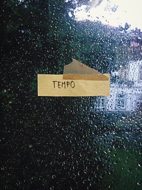 Foto texto preso na janela de vidro da casa durante a estação chuvosa